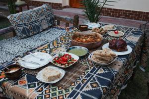 a table with plates of food on a table at Golden Palace Family in Luxor
