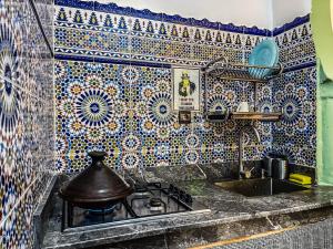 a kitchen with a stove and a tiled wall at Tangier Kasbah Hostel in Tangier