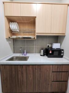 a kitchen with a sink and a microwave at 2 bedroom apartment 5 people in Nilai