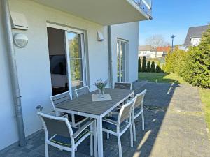 einen Holztisch und Stühle auf einer Terrasse in der Unterkunft Haus Sonne - FeWo 01 Sandperle in Thiessow
