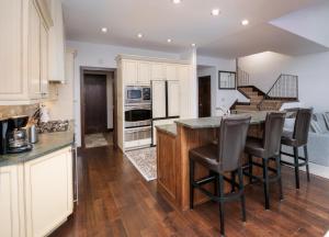 a kitchen with white cabinets and a island with bar stools at Wildflower Place Unit 5 in Edwards