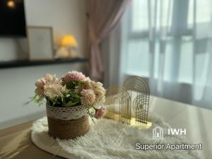 a vase of flowers sitting on top of a table at Ipoh Anderson Town Suites with 2 Parking by IWH in Ipoh