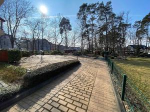 a brick path in a park with a fence and trees at Villa Mara Wohnung 09 mit Balkon in Baabe