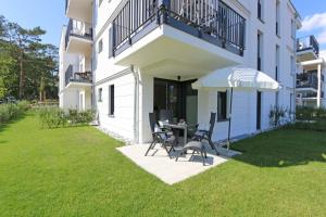 a patio with a table and chairs and an umbrella at Villa Strandläufer Whg. 23 MeerMomente mit Terrasse in Baabe