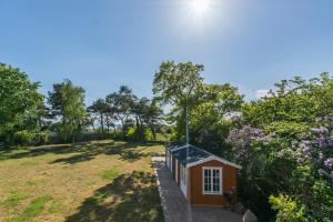 een klein huis in een tuin met bomen bij Villa Westwind in Thiessow