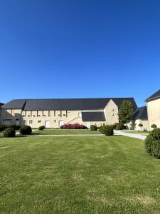 a large building with a green lawn in front of it at DOMAINE DU GRAND CAUGY in Saint-Vigor-le-Grand