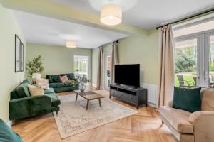 a living room with a couch and a tv at Stunning coastal 6/bed house w/parking & garden in Cromer