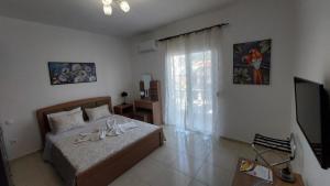 a bedroom with a bed with a television and a window at George & Chrysi Apart in Kremasti +31 photos