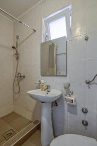 a bathroom with a sink and a mirror and a shower at Apartmani Marina in Sutomore