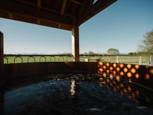 a hot tub on the back porch of a house at Les Cabanes Du Lizon in Bernadets-Dessus