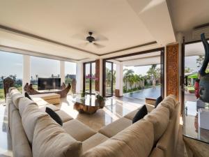 a living room with a large couch and a tv at Villa Luwih in Canggu