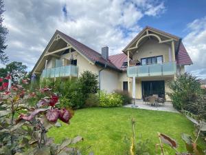ein großes Haus mit einem Garten mit Rasen sidx sidx sidx in der Unterkunft F Haus Sterntaucher Whg 01 mit Terrasse in Thiessow