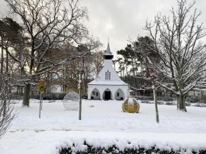 una iglesia blanca con un campanario en la nieve en Haus Meeresblick A 126 Seegeflüster mit Terrasse, en Baabe