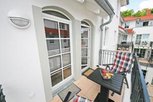 - un balcon avec une chaise et une corbeille de fruits dans l'établissement Haus Meeresblick A 2 05 Baabedos mit Balkon, à Baabe