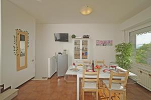 a kitchen with a table and chairs and a refrigerator at Petronella - Gardagate in Soiano del Lago