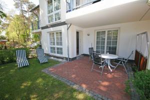 eine Terrasse mit einem Tisch und Stühlen im Hof in der Unterkunft Villa Mara - FeWo 03 in Baabe