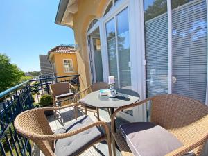 a patio with chairs and a table on a balcony at Kurparkresidenz Baabe Whg 15 mit Balkon in Baabe