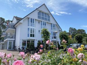 ein weißes Gebäude mit Blumen davor in der Unterkunft Ferienwohnung Ostseebrise in Baabe