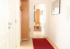 einen Flur mit einem roten Teppich auf dem Boden in der Unterkunft Villa Heimkehr - FeWo 08 in Göhren