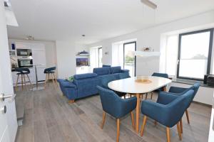 ein Wohnzimmer mit einem Tisch und blauen Stühlen in der Unterkunft Haus Granitz Whg. 5.3 mit Dachterrasse und Sauna in Binz