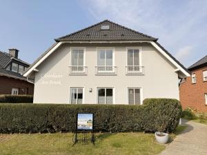 una casa blanca con un cartel delante en Gästehaus am Brook mit 5 Ferienwohnungen, en Moritzdorf