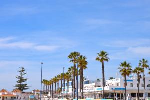 a row of palm trees in front of a building at Casa Lea in Islantilla