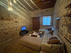 a living room with a couch and a tv in it at Stone House in Antalya in Antalya