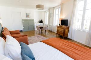 a bedroom with a bed and a living room at Aux Couleurs de Neuvy in Neuvy-Saint-Sépulchre