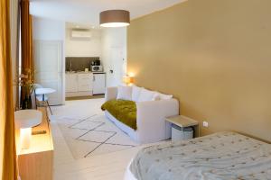 a bedroom with a bed and a couch in a room at Aux Couleurs de Neuvy in Neuvy-Saint-Sépulchre