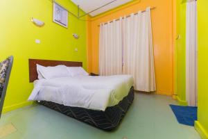 a bed in a room with green and orange walls at Hotel Southern Blue in Nairobi