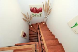 uma escadaria com pisos de madeira e flores na parede em Moradia Chicharro na Nazaré