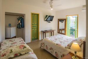 a bedroom with two beds and a green door at Pousada da Sirlei in Tiradentes +280 photos