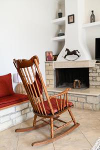 a wooden rocking chair in a living room with a fireplace at Oleopetra in Vromonérion