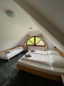 a attic bedroom with two beds and a window at Pod Orlicą in Duszniki Zdrój