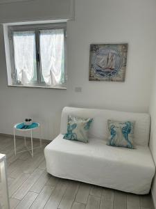 een witte bank in een woonkamer met een raam bij SoleeMare Barletta Apartments in Barletta