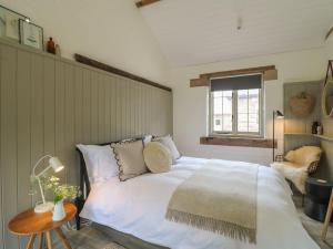 a bedroom with a large white bed and a table at Ash Cottage - Fold Yards in Belper