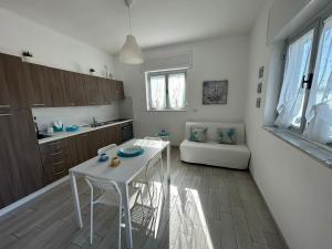 een keuken met een witte tafel en een witte bank bij SoleeMare Barletta Apartments in Barletta