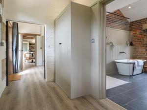a bathroom with a bath tub next to a brick wall at Ash Cottage - Fold Yards in Belper +13 photos