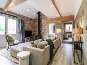 ein Wohnzimmer mit Couch und Kamin in der Unterkunft Holly Cottage - Fold Yards in Belper