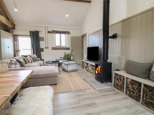 a living room with a couch and a fireplace at Hazel Cottage - Fold Yards in Belper