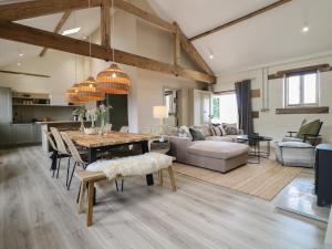 a dining room and living room with a wooden table at Hazel Cottage - Fold Yards in Belper