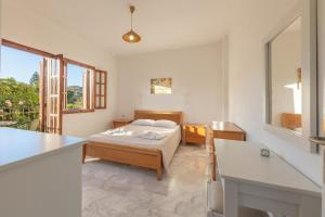 Schlafzimmer mit einem Bett, einem Tisch und einem Fenster in der Unterkunft Ζini 2 in Kefalos