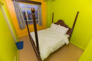 a bedroom with a bed in a green room at Hotel Southern Blue in Nairobi