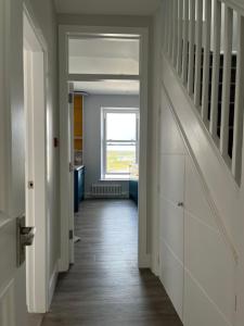 a hallway of a house with a staircase and a window at Carrick Rooms in Port Saint Mary