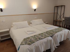 コンスエグラにあるSG ROOMSのベッドルーム1室(白いシーツが備わるベッド2台付)