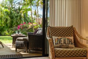 a porch with a wicker chair and a table at Maui Kamaole K104 in Wailea