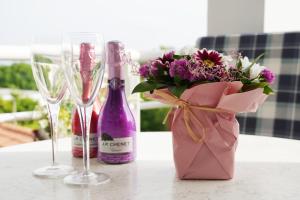 a table with two wine glasses and a bouquet of flowers at Apartman Mare in Dramalj +16 photos