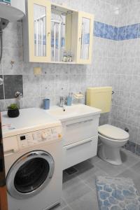 a bathroom with a washing machine and a toilet at Apartman Mare in Dramalj