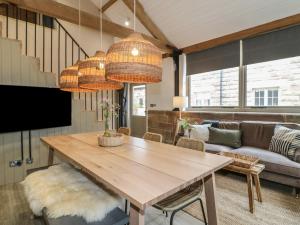 ein Wohnzimmer mit einem Holztisch und 2 Kronleuchtern in der Unterkunft Elm Cottage - Fold Yards in Belper
