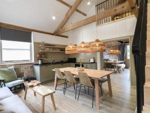 eine Küche und ein Esszimmer mit einem Holztisch und Stühlen in der Unterkunft Elm Cottage - Fold Yards in Belper
